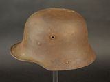 an old helmet is sitting on a stand against a gray background
