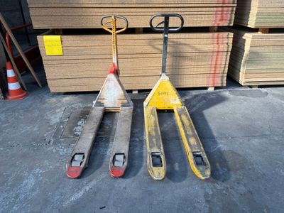deux palettes placées l'une à côté de l'autre devant une pile de cartons