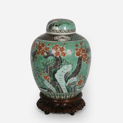 a green vase with a picture of a woman on it