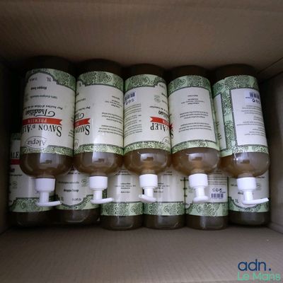 plusieurs flacons de gel hydroalcoolique dans une boîte en carton