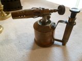 un petit objet en laiton posé sur le sol à côté d'une lampe