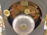 a silver clock with a gold clock face on it