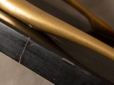 a gold baseball bat sitting on top of a black table