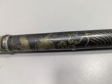 an image of a black and gold pen sitting on top of a white table