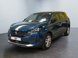 Une voiture bleue est garée dans une pièce aux murs blancs.