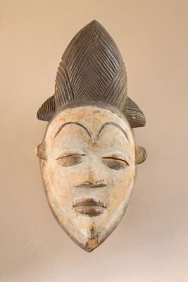 an image of a wooden mask hanging on a wall