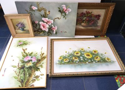 quatre photos encadrées représentant des fleurs et des oiseaux, posées par terre