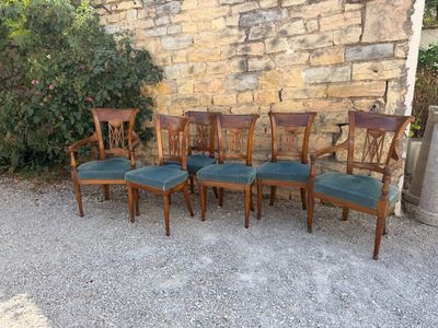 six chairs sitting next to each other in front of a stone wall