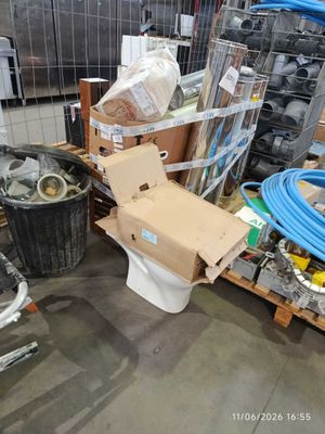 a toilet in the middle of a room with a lot of items