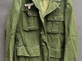 une vieille veste militaire suspendue à un cintre accroché au mur