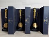 three bottles of champagne in a blue box on a table