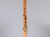 a wooden clarinet with a black top and gold hardware