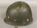 an old army helmet is sitting on top of a table