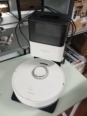 a white and black robot sitting on top of a glass table