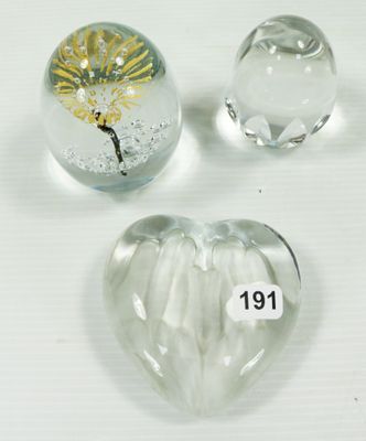 trois presse-papiers en verre en forme de cœur posés sur une surface blanche