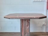 a wooden table with a metal base in a room