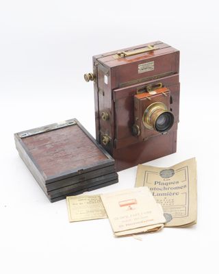 a small wooden box with a camera and some papers