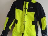 un gros plan sur une veste jaune et noire accrochée à un mur