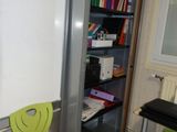 a green chair sitting in front of a whiteboard in a room