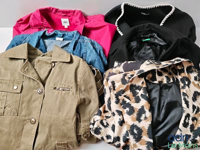 Plusieurs vestes sont alignées sur une surface blanche