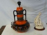 deux vases posés sur une table, avec une statue en arrière-plan