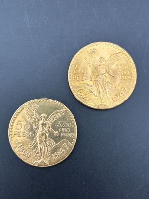 deux pièces d'or posées sur une surface noire, sur fond bleu