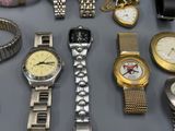 many different types of watches displayed on a table
