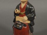 figurine chinoise représentant un homme tenant un panier et chantant