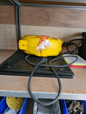 un sèche-cheveux jaune posé sur un établi