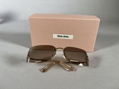 sunglasses in a box on a table with a pair of scissors