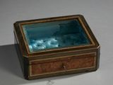 une petite boîte contenant un verre, posée sur une table