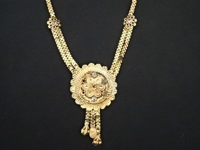 un gros plan d'un collier en or orné d'une tête de lion