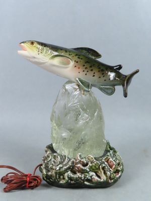 statue représentant un poisson assis sur un rocher, à côté d'une ficelle