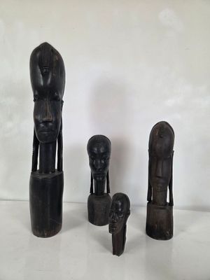 trois sculptures en bois représentant une femme, un homme et un enfant