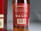 a bottle of wine sitting next to a red box