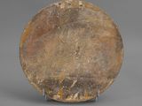 an image of a brown plate on a stand on a gray surface