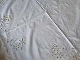 a white table cloth with a lace edge on a table