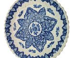 a blue and white plate with a flower design on it