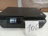 a black printer sitting on a table with a note in front of it