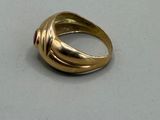 a gold ring with a red stone in it