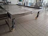 une grande table en acier inoxydable au milieu d'une cuisine