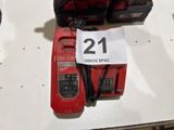 a red corded drill and two other tools on a table