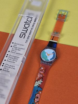 a watch sitting on a table next to a plastic box