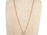 a gold chain necklace with a diamond pendant on a mannequin mannequin