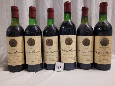 six bottles of red wine are lined up on a table