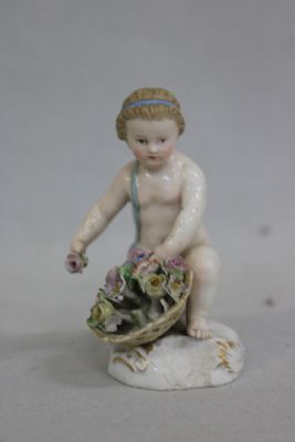 une figurine représentant un enfant avec un panier de fleurs
