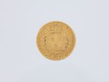 a close up of a gold coin on a white surface