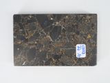 a black marble slab with a blue sticker on it