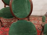 three green chairs sitting on top of a red rug on top of a wooden floor