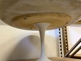a marble table with a white pedestal on the floor